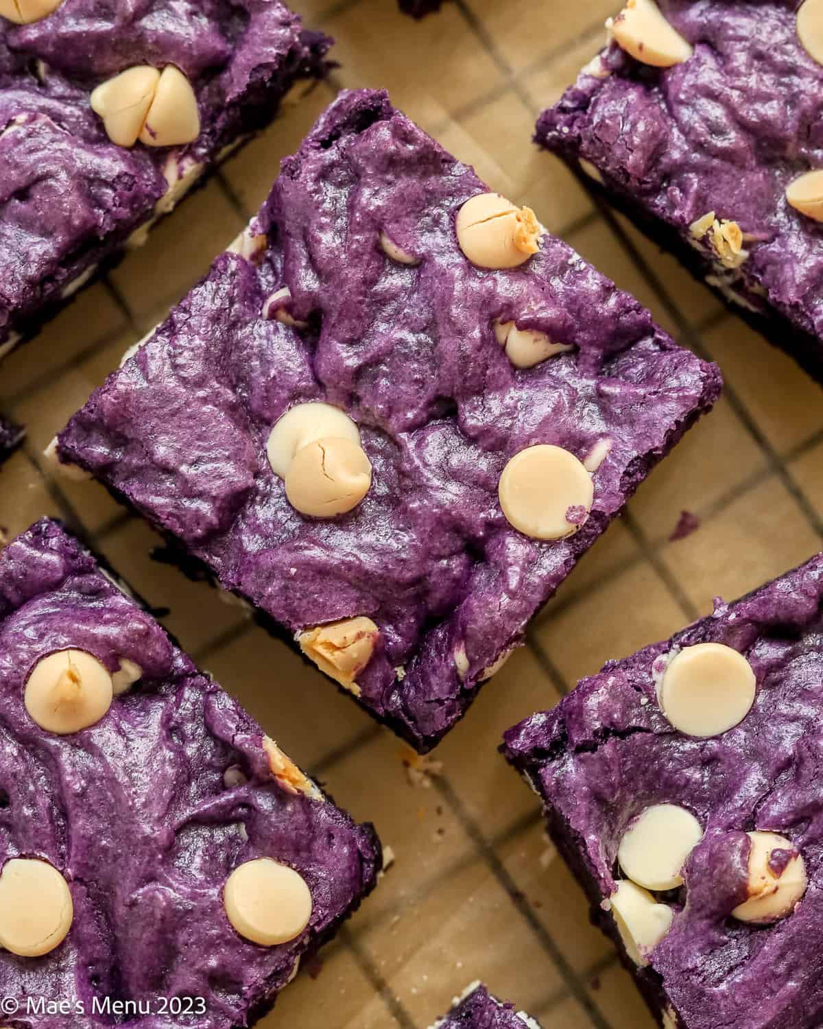 An up-close overhead shot of the ube brownies on a parchment paper lined cooling rack.