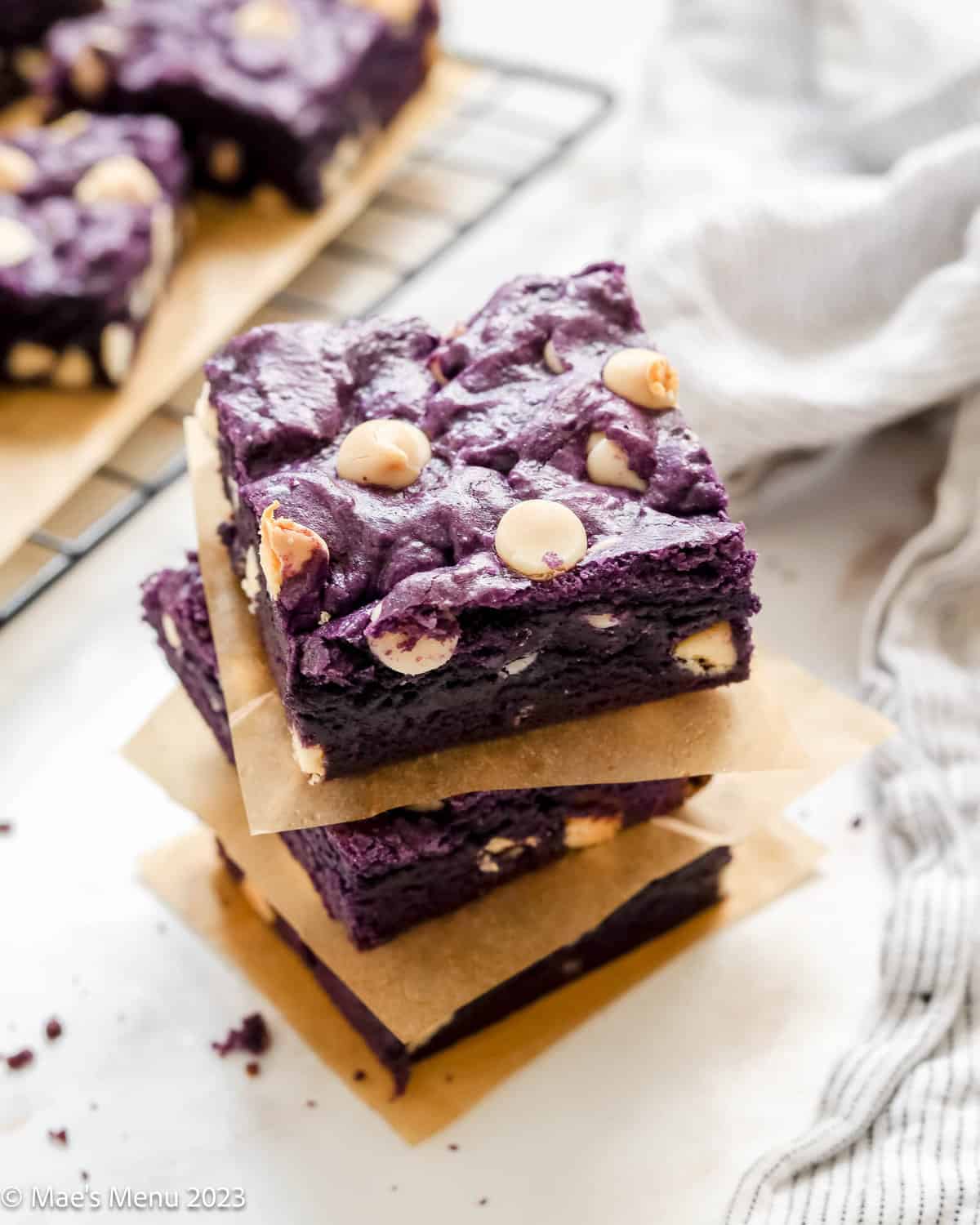 A stack of ube brownies with parchment paper between them.
