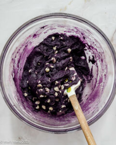 A glass mixing bowl of ube brownie batter.