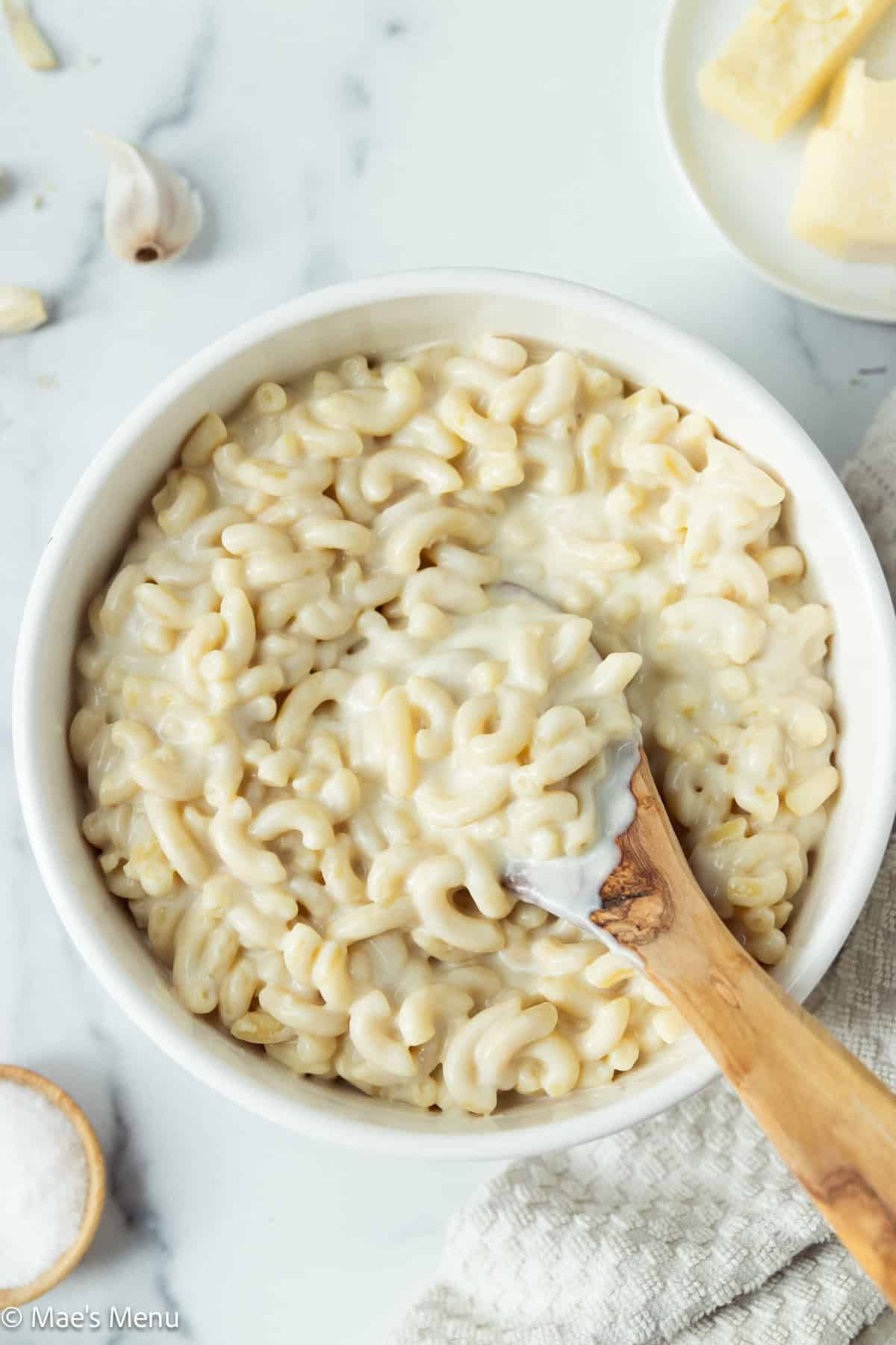 An overhead shot of a large serving bowl of white cheddar mac and cheese.