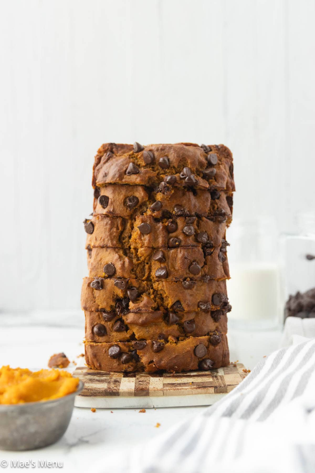 A further-back shot of a stacked loaf of sliced pumpkin banana brea don the counter.