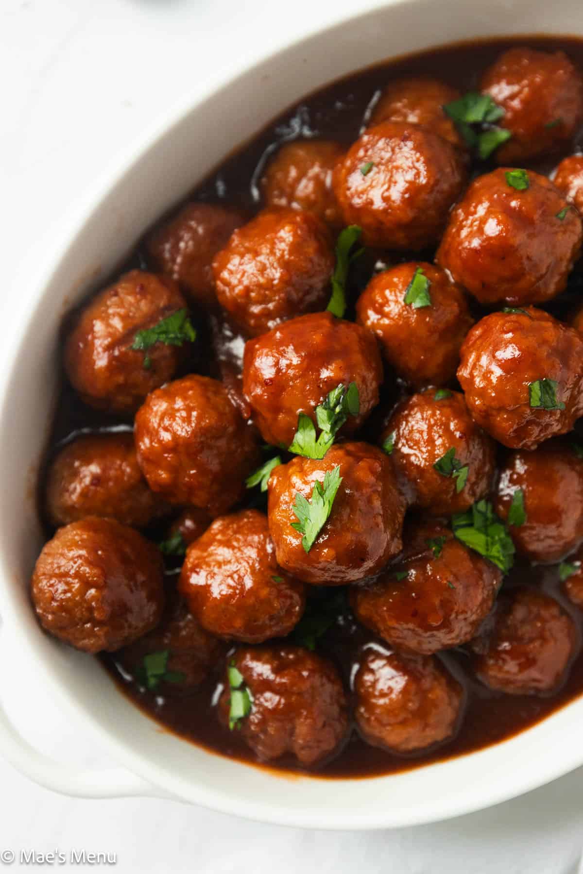 Closeup overhead shot of a bowl of cranberry cocktail meatballs.