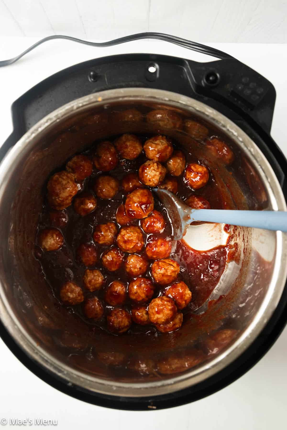 Frozen meatballs mixed with the cranberry meatballs sauce in the instant pot. 