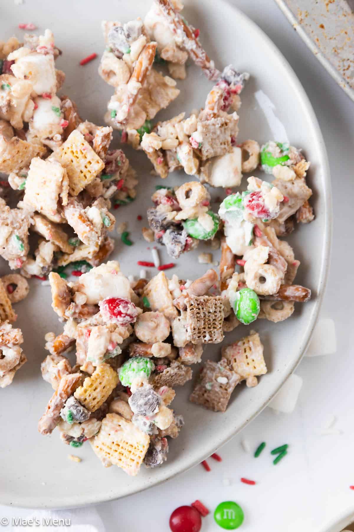 A close up overhead shot of a plate of the Christmas chex mix. 