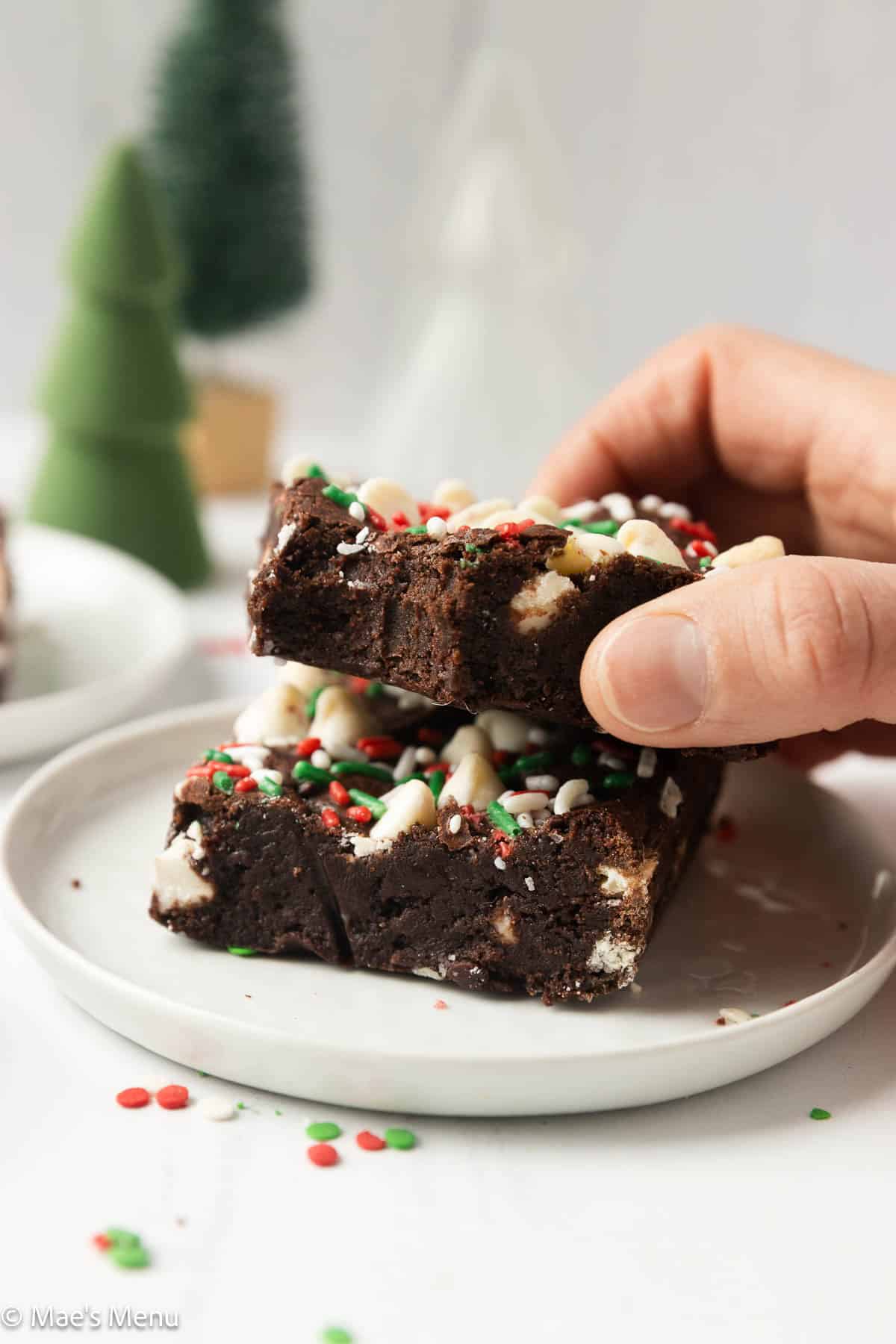 Taking a peppermint Christmas brownie off of the stack on a small plate.