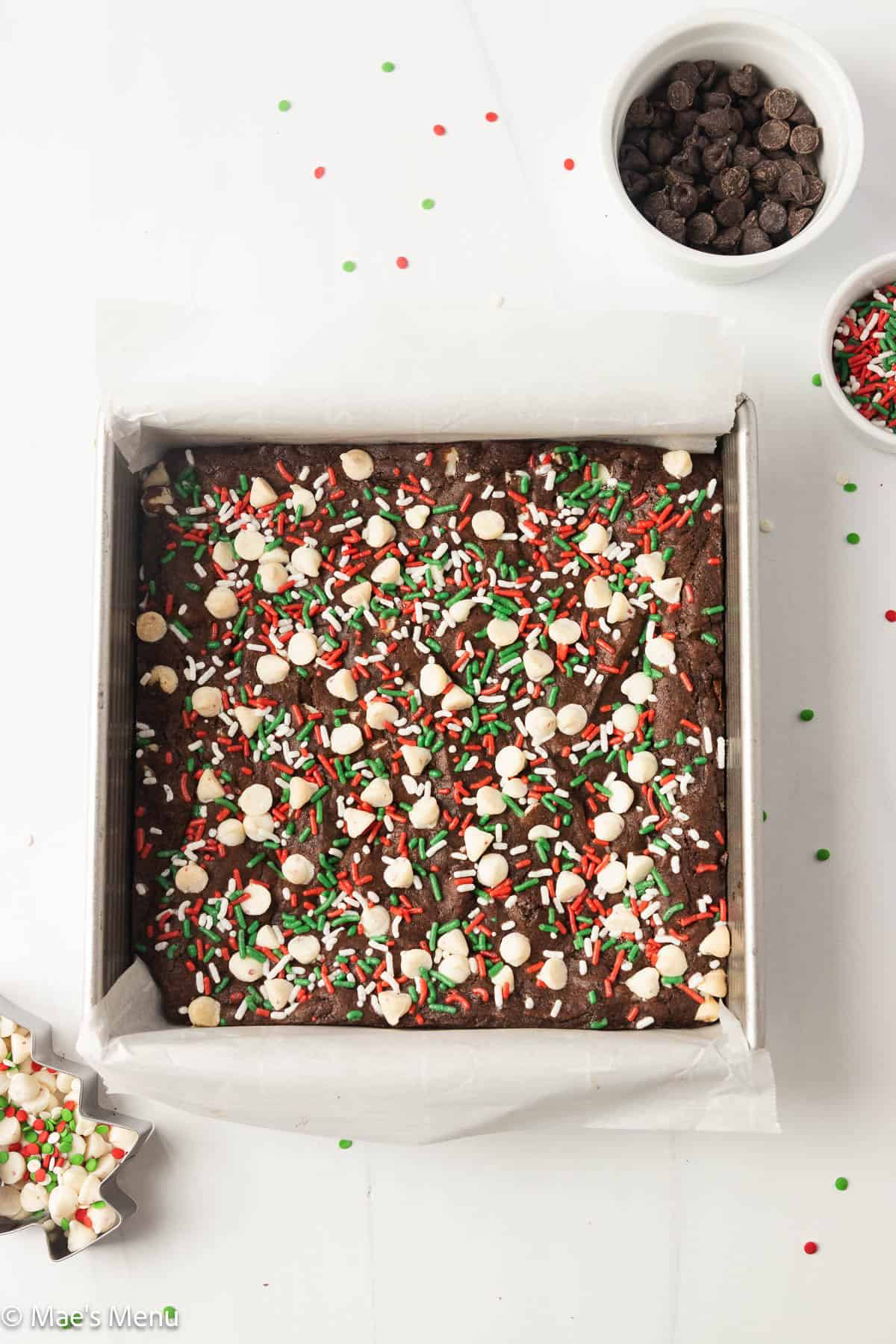 An overhead shot of a pan of Christmas peppermint brownies on the counter. with chips and sprinkles.