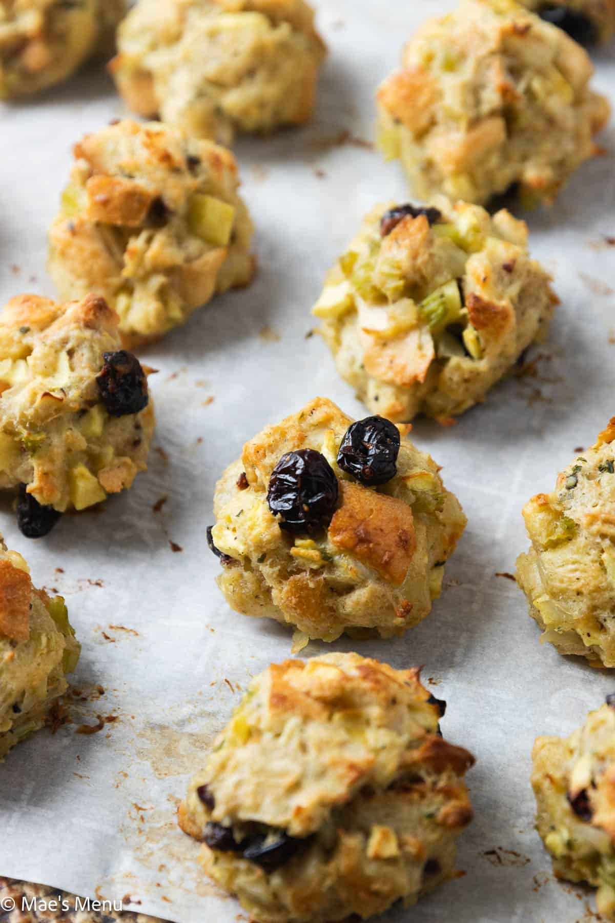 A close-up shot of baked stuffing balls on a baking sheet.