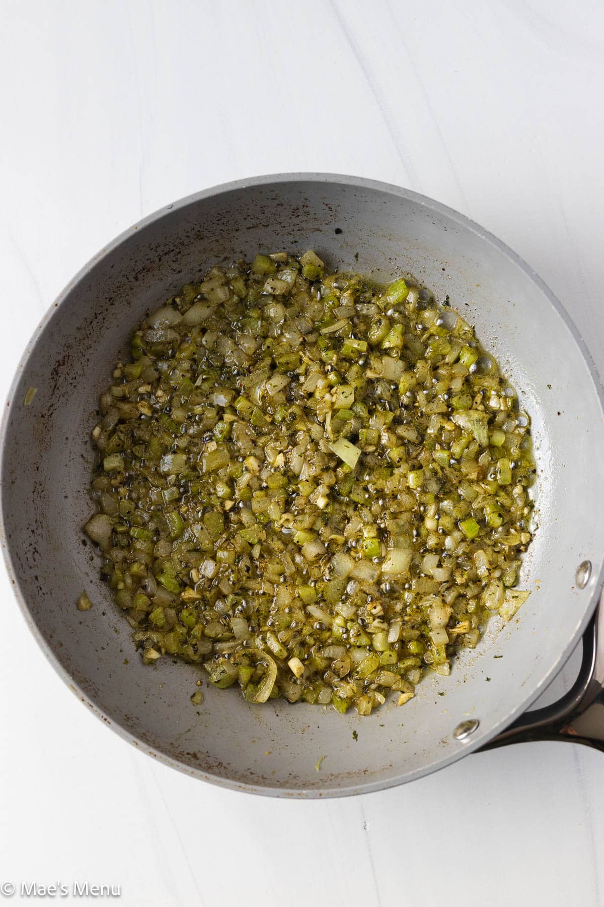 An overhead shot of a skillet of the seasoned celery and onions.