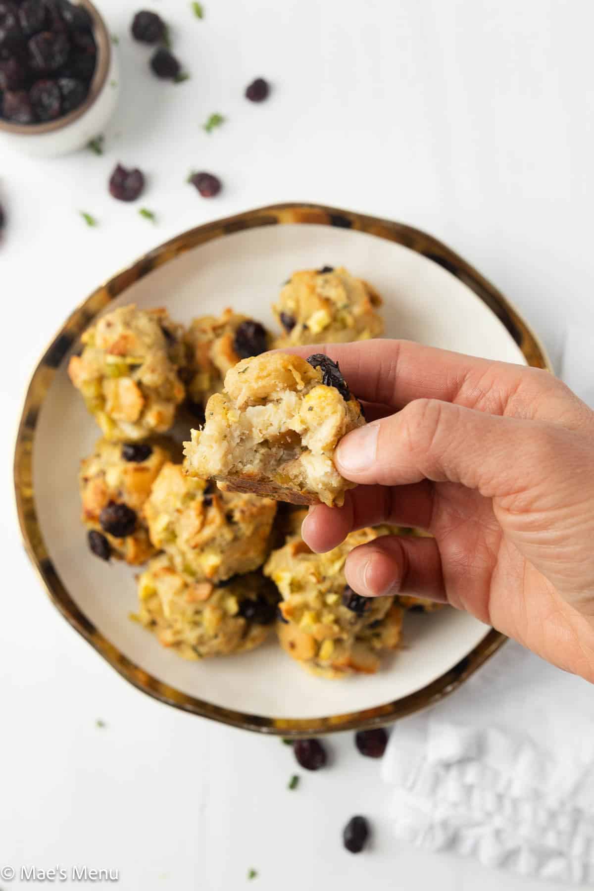 Holding a stuffing ball with a bite taken out of it over the bowl of the balls.