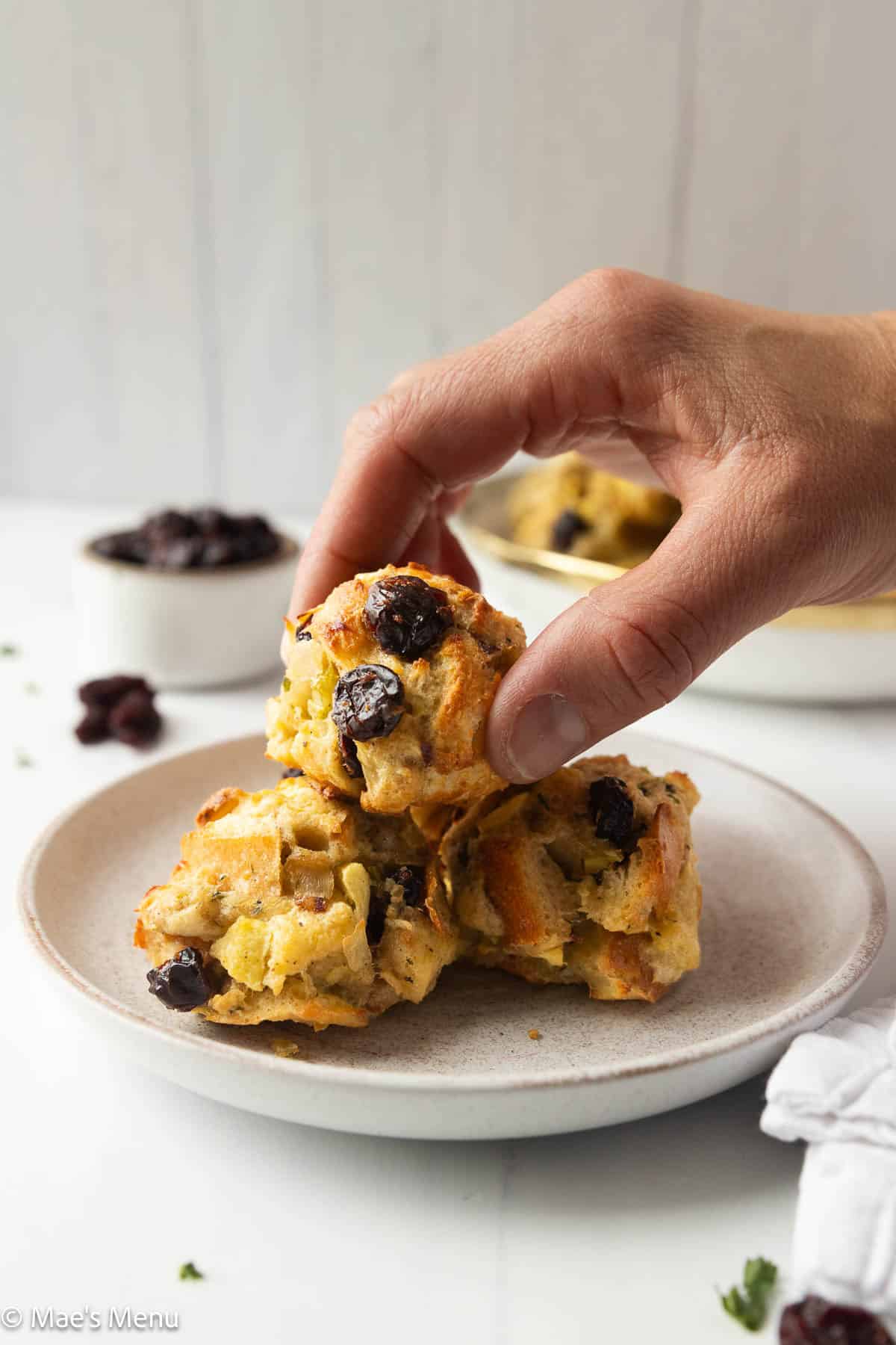 A hand grabbing a stuffing ball from a stack.
