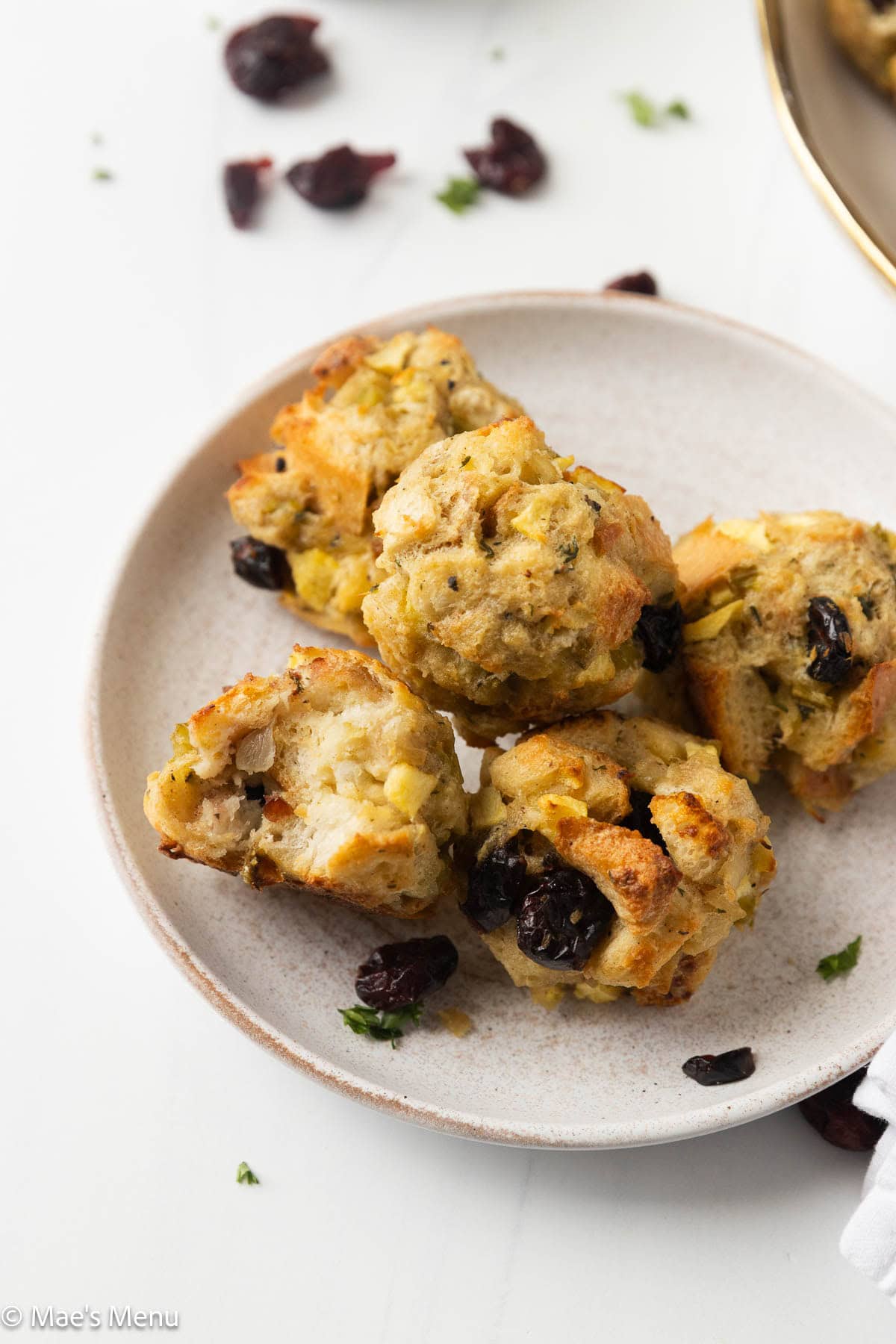 A close up shot of a few stuffing balls on a small plate with a bite taken out of one.
