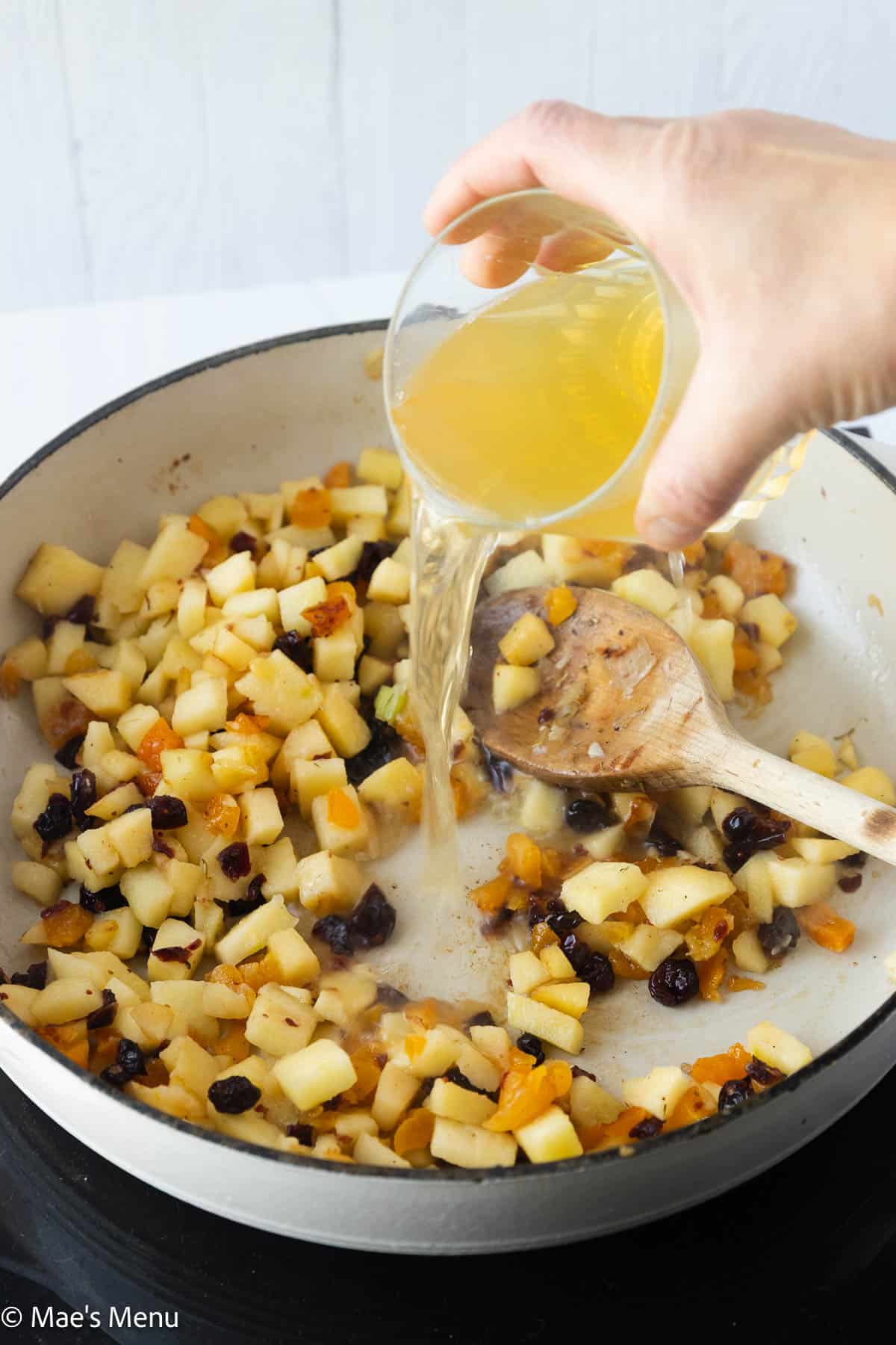 Deglazing the pan with a splash of chicken broth.