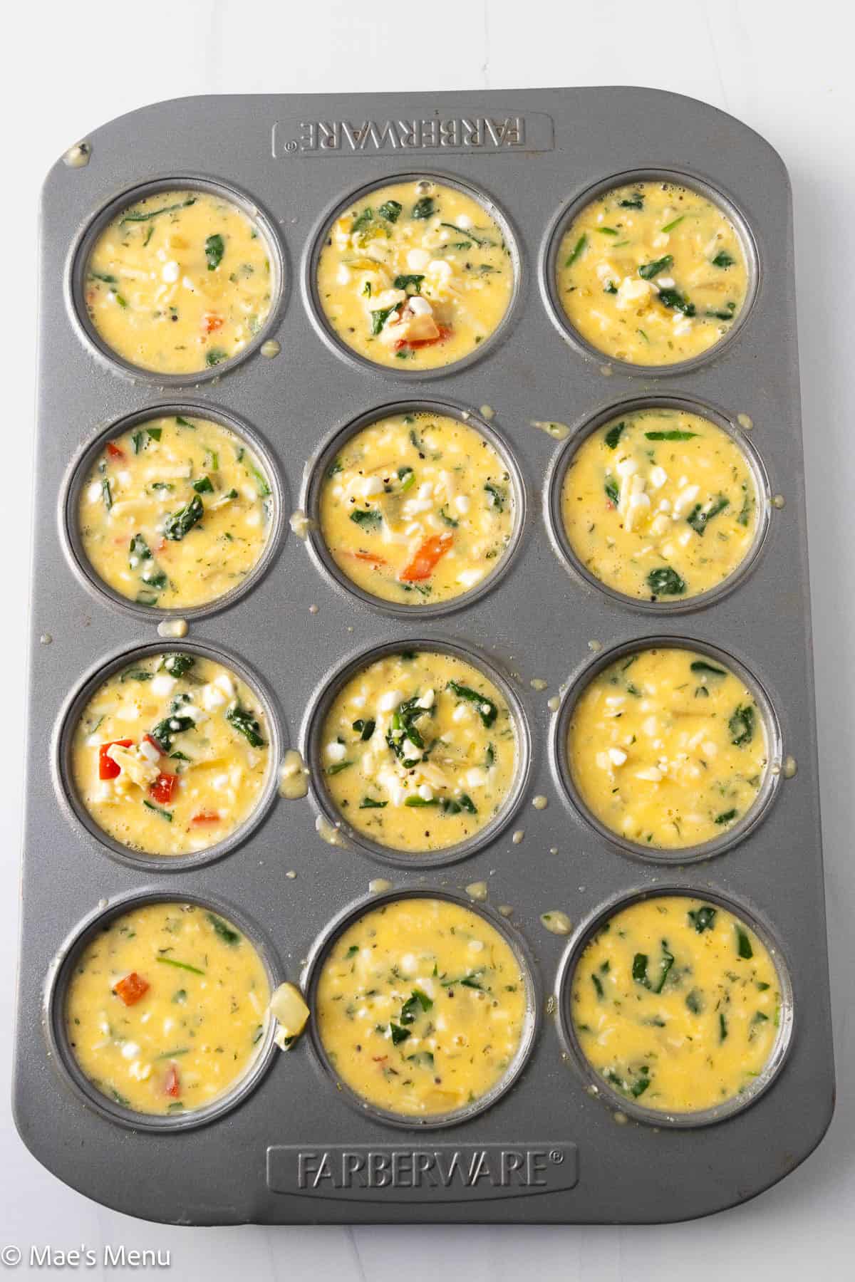 A muffin pan full of the cottage cheese egg bites before baking.