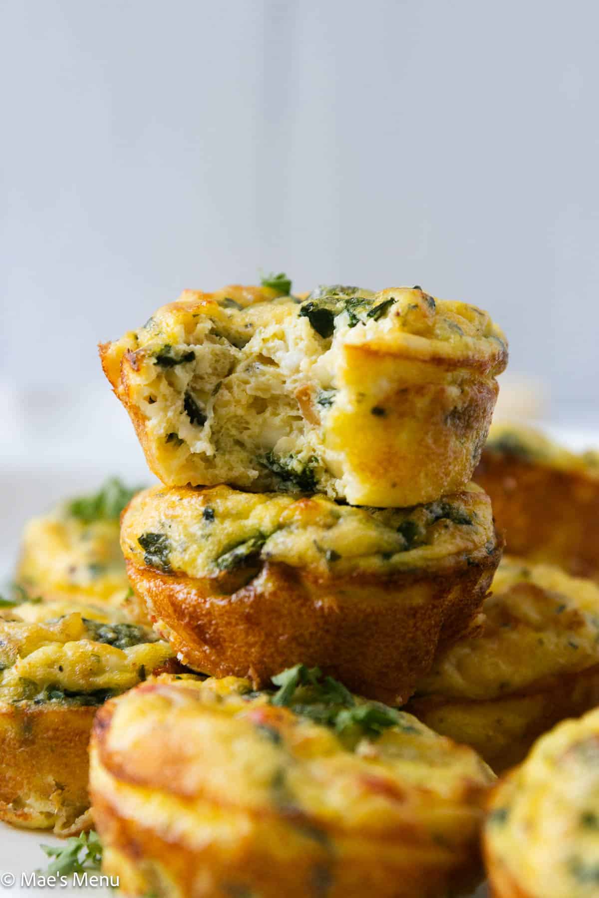 A stack of high protein egg muffins with cottage cheese with a bite taken out of the top