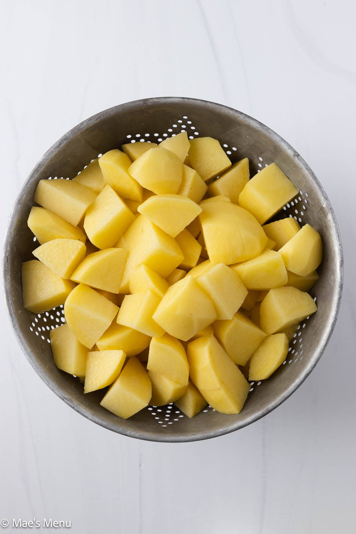 Cubed potatoes in a colander.