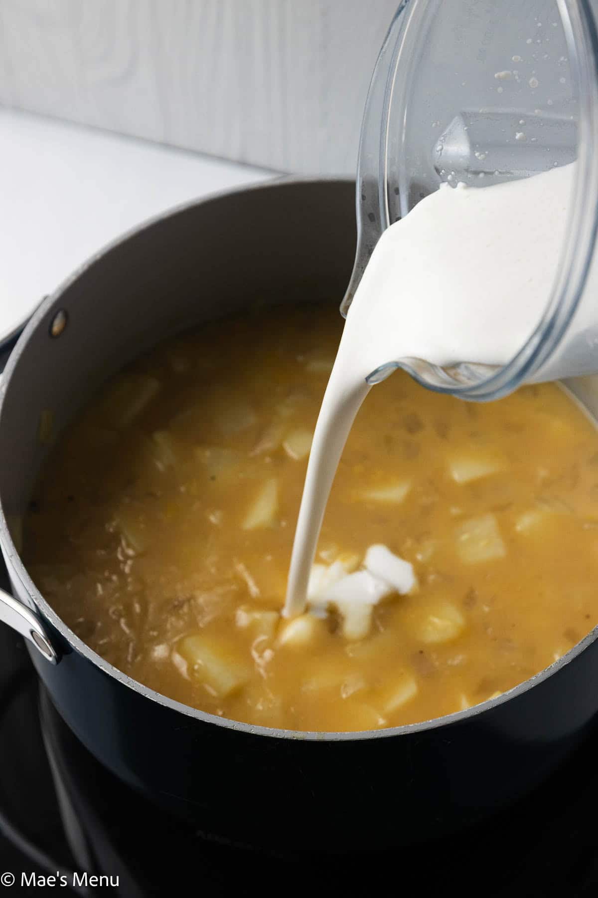 Pouring the blended cottage cheese into the soup.