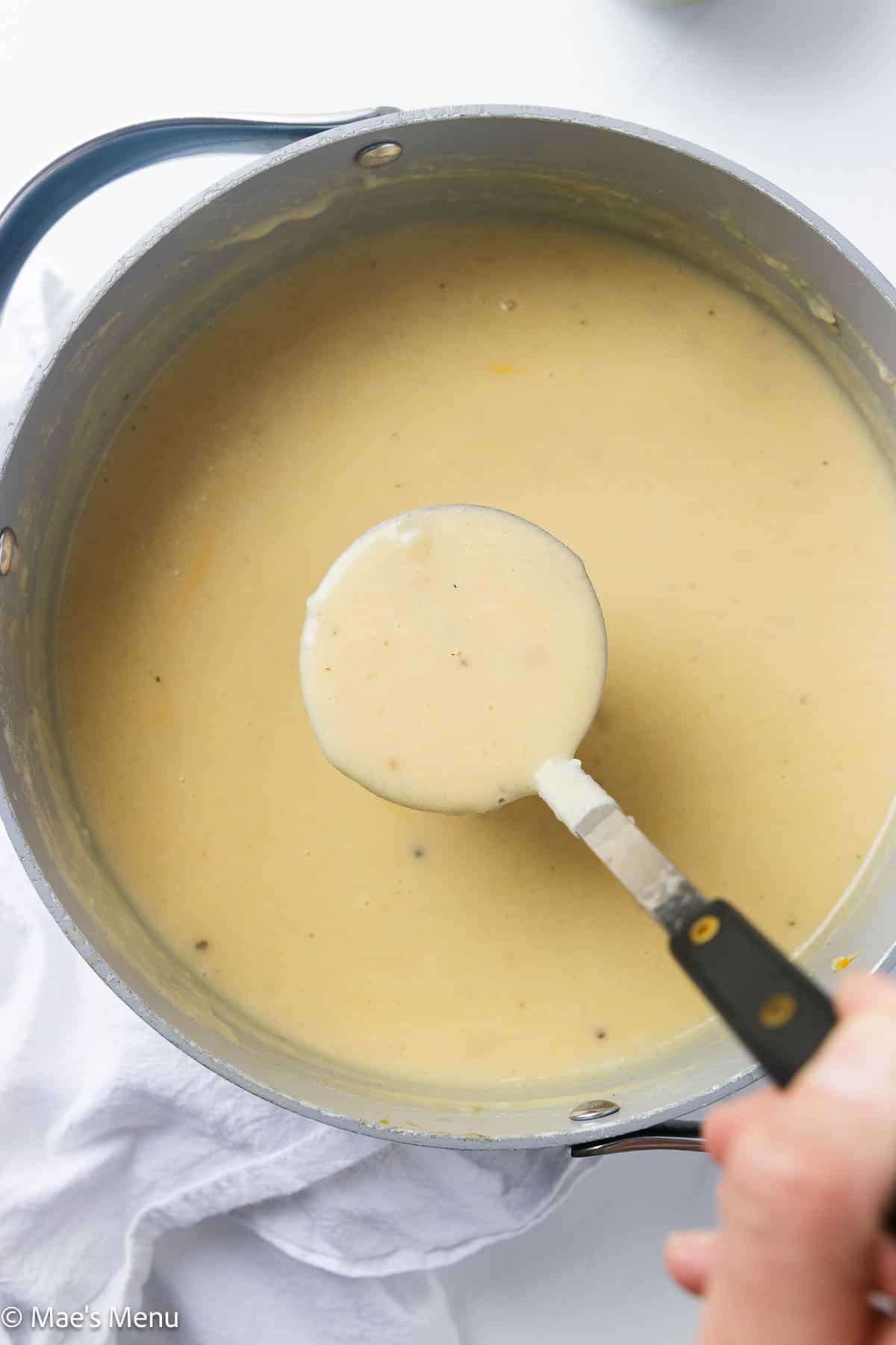 Ladling protein potato soup from a bowl.