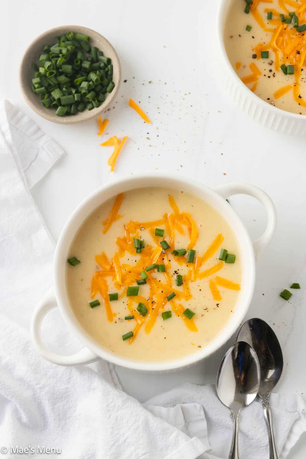 An overhead shot of two bowls of cottage cheese potato soup on the counter.