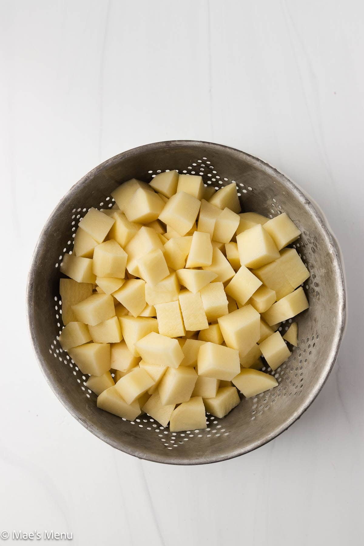 Drained rinsed potatoes in a colander.