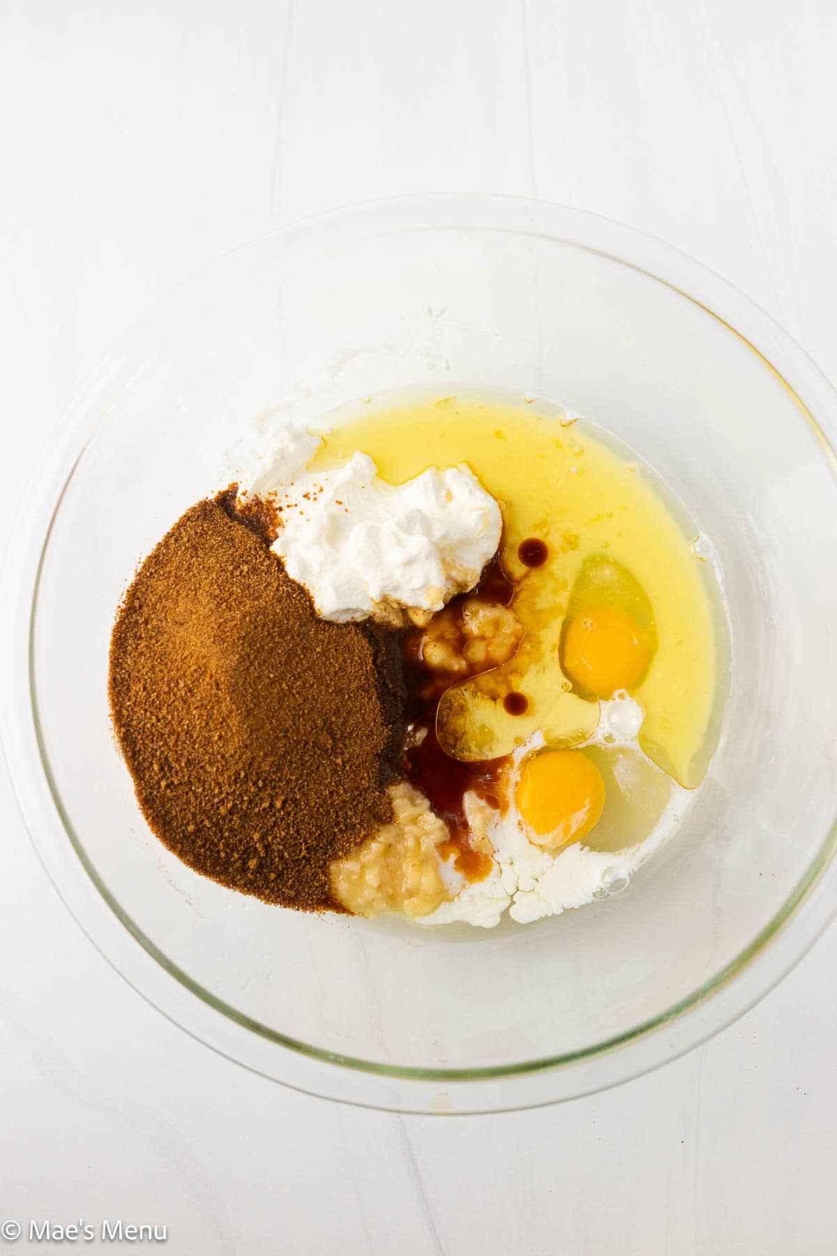 An overhead shot of the wet ingredients for the high protein banana bread in a glass mixing bowl.
