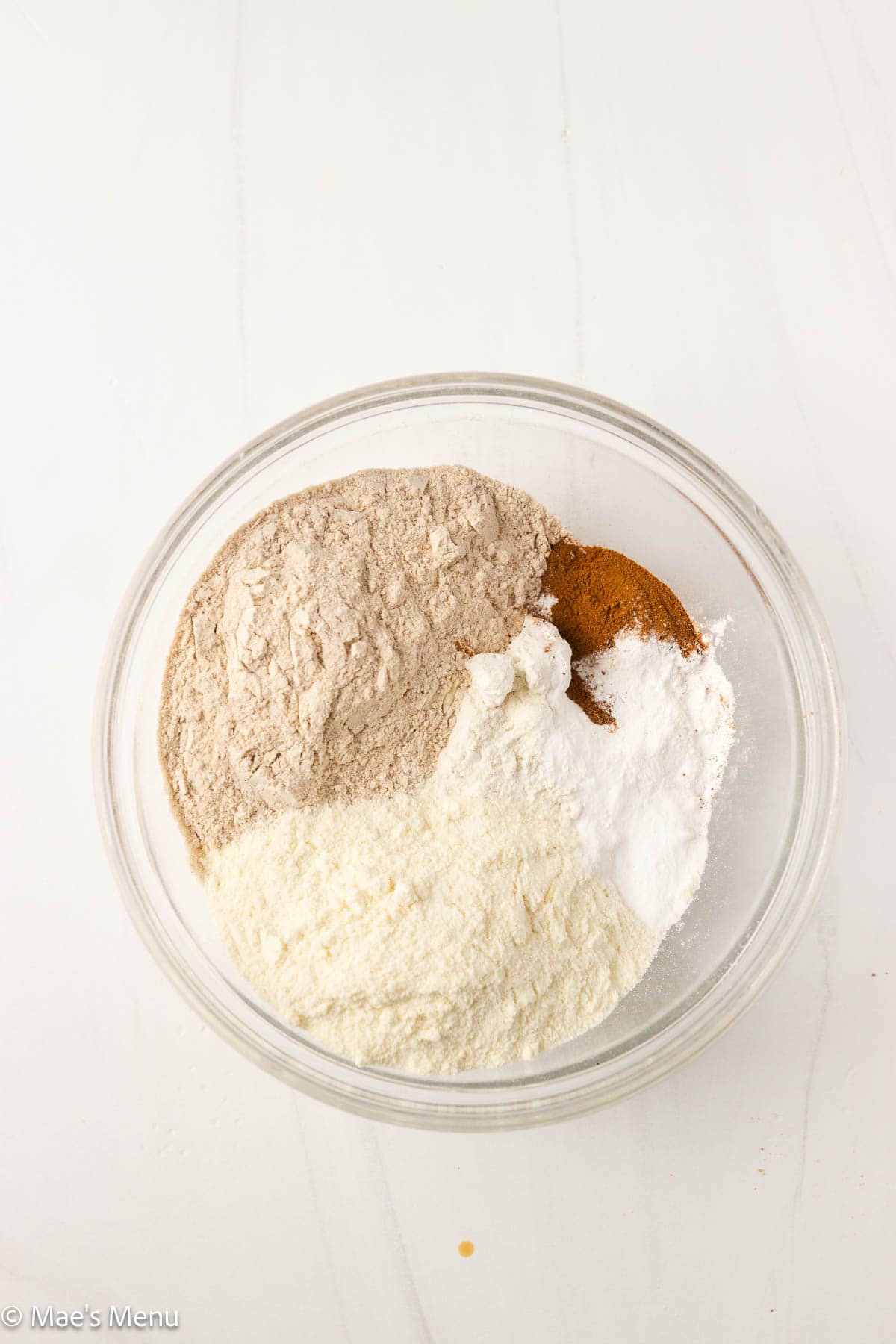 An overhead shot of the dry ingredients for high protein banana bread in a small glass mixing bowl.