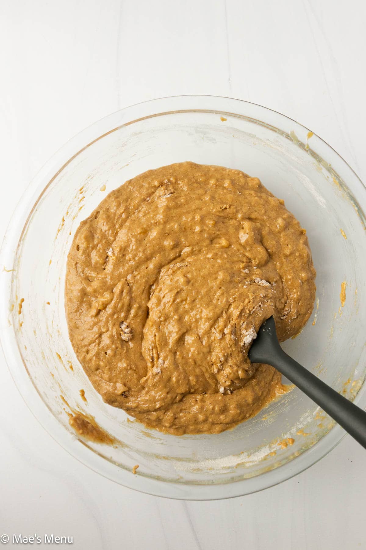 An overhead shot of the high protein banana bread batter in a glass mixing bowl.