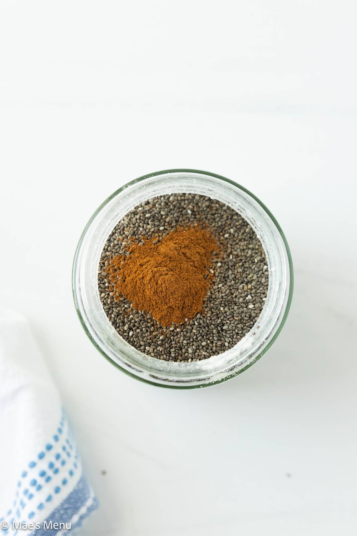 A small glass jar with chia seeds and cinnamon in it. 