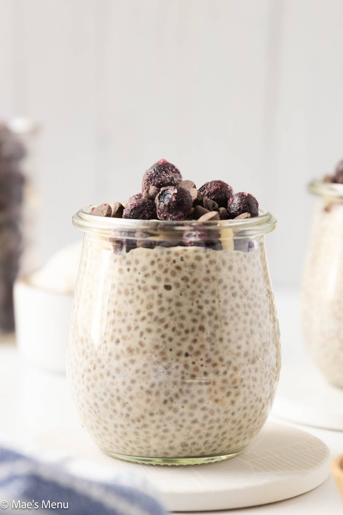 A close-up side shot of a glass cup of protein chia pudding.