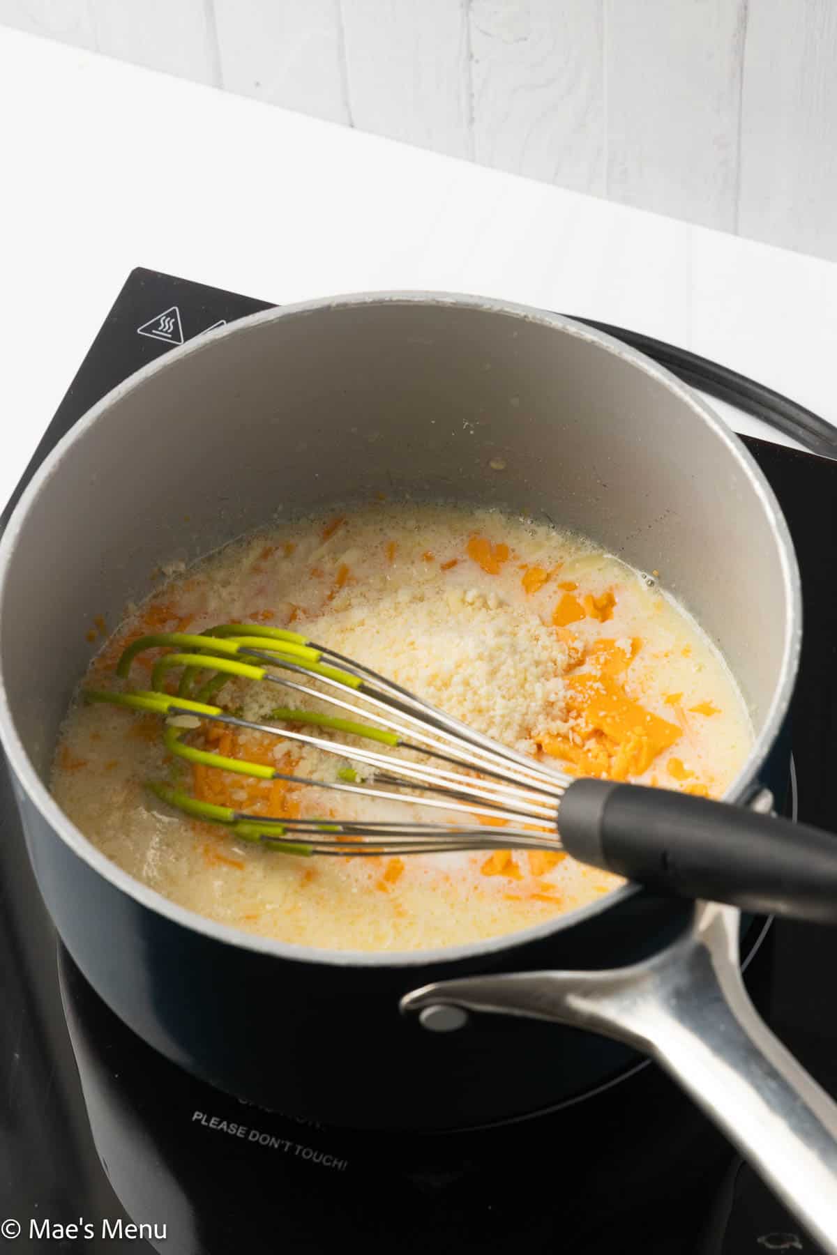 A saucepan with the roux, milk, and cheese.