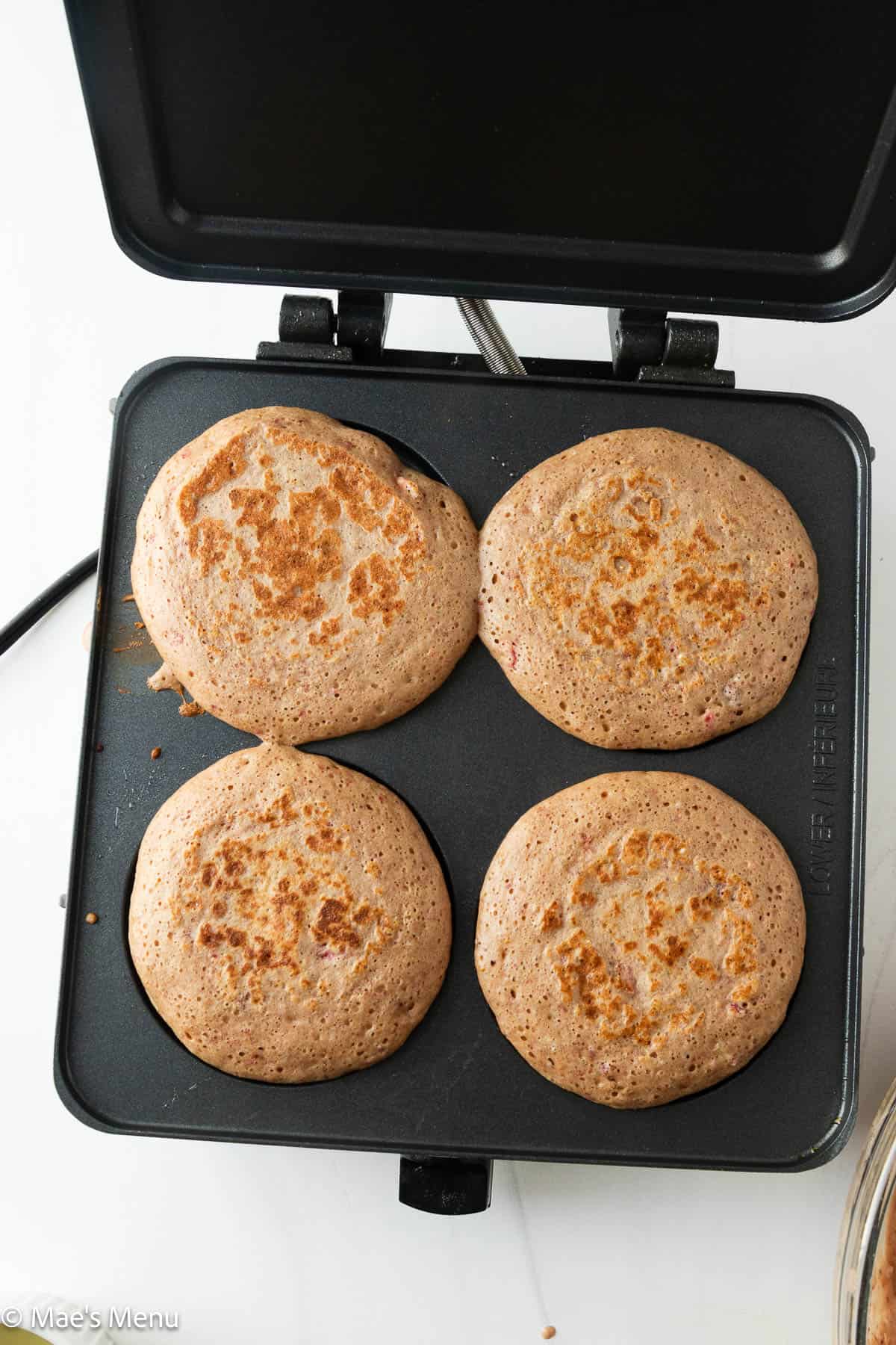 Cooked high protein strawberry pancakes on a pancake plate.