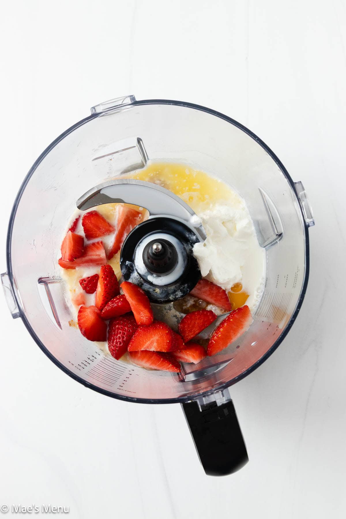 The strawberry and wet ingredients in the food processor before blending.