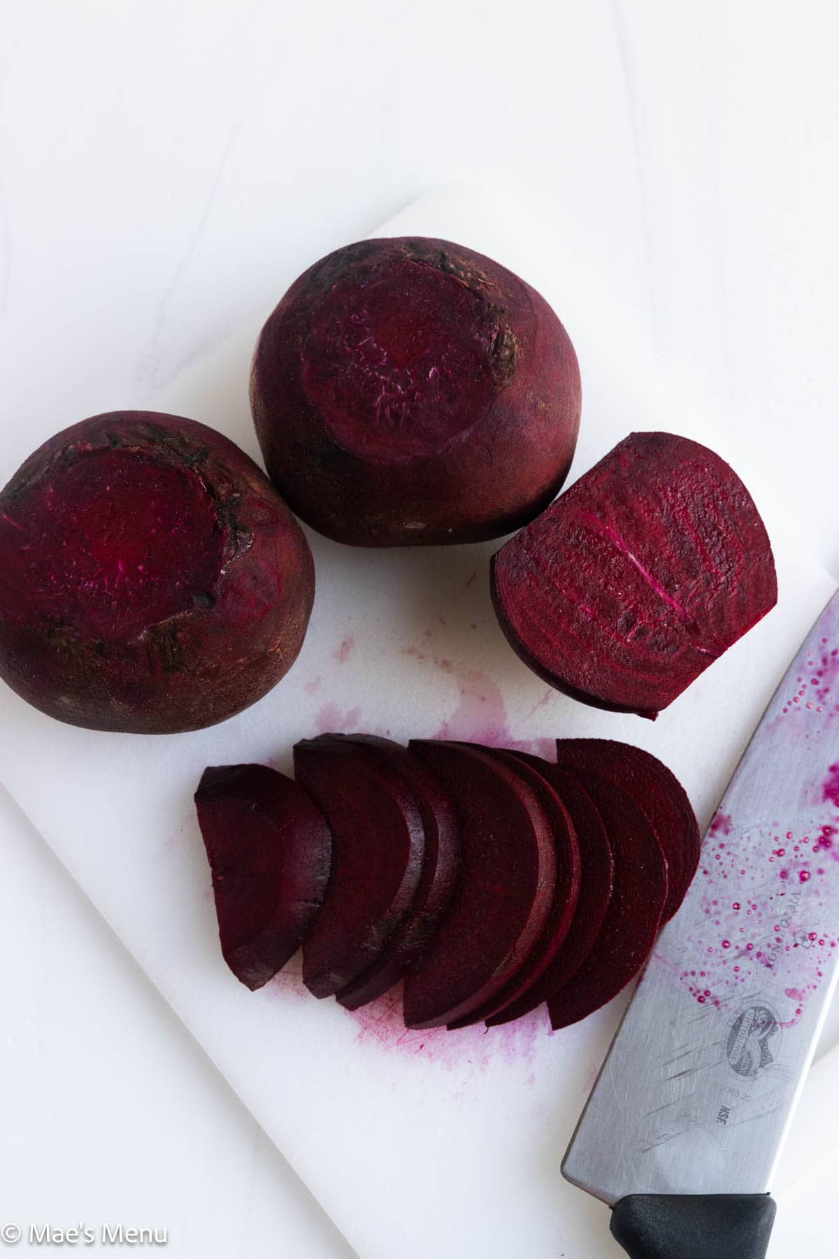 Chopped beets on a cutting board with a knife.