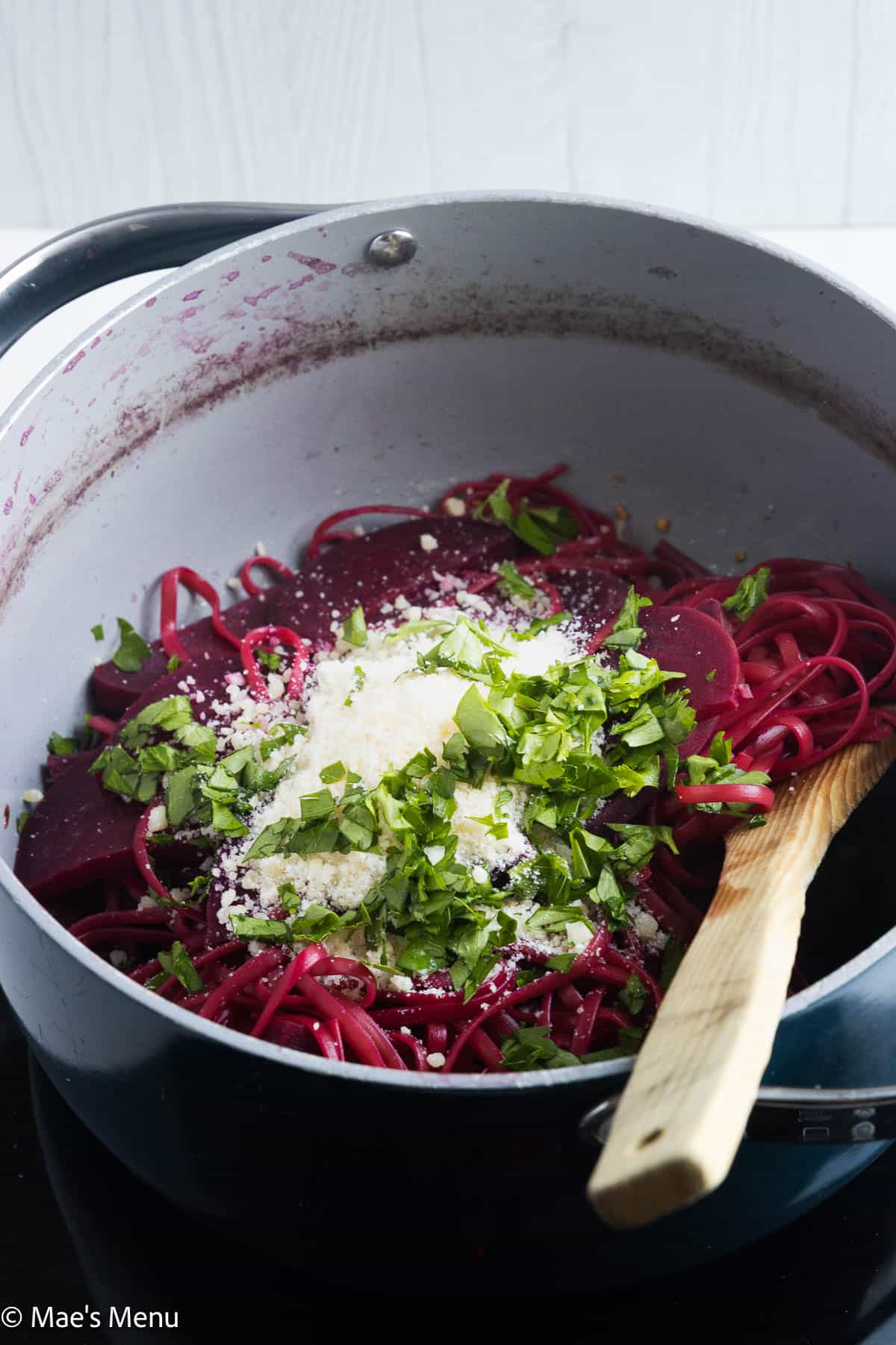 A pan of the pink pasta topped with parsley and grated parmesan.