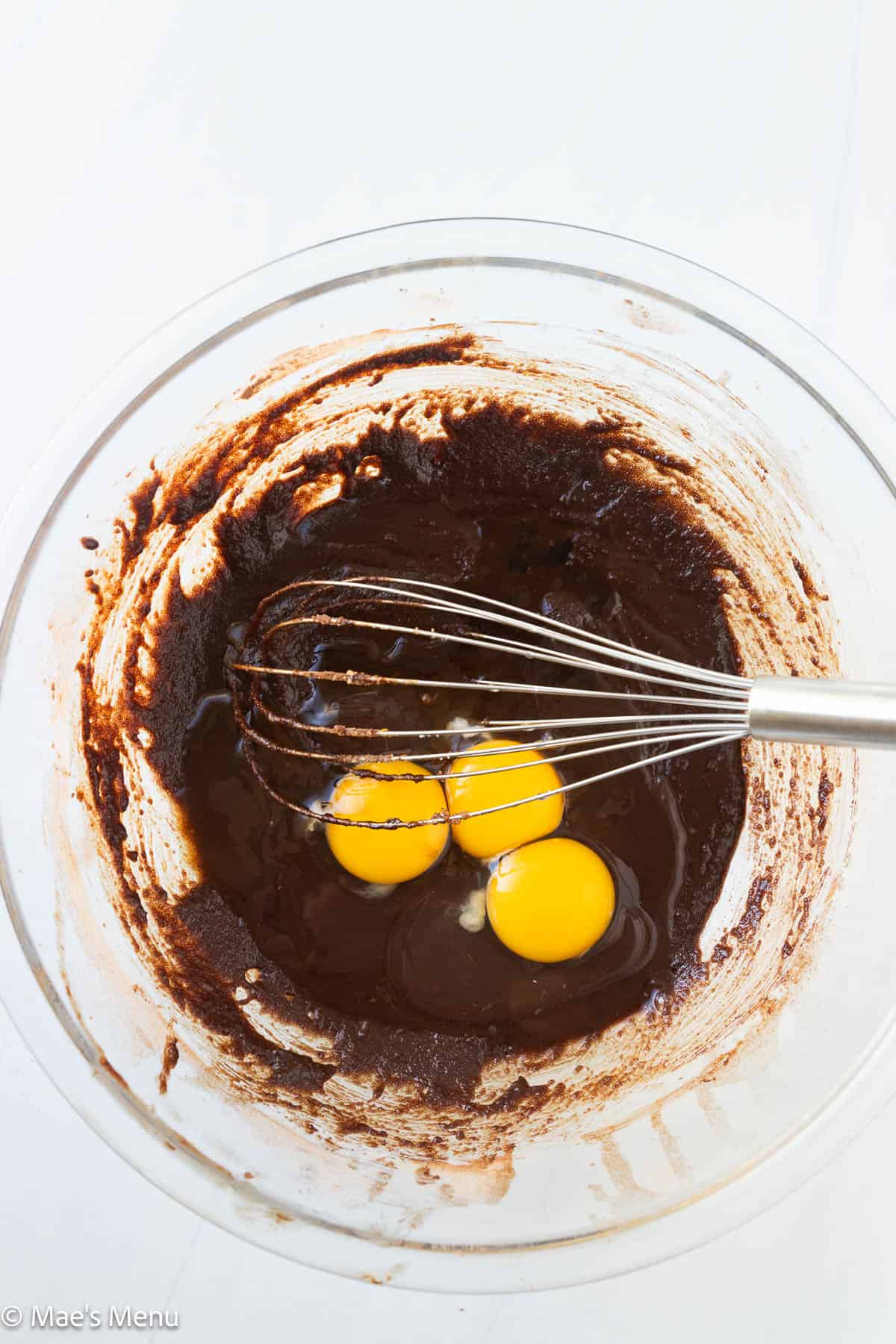 A mixing bowl with the eggs and vanilla added to the brownie batter base.