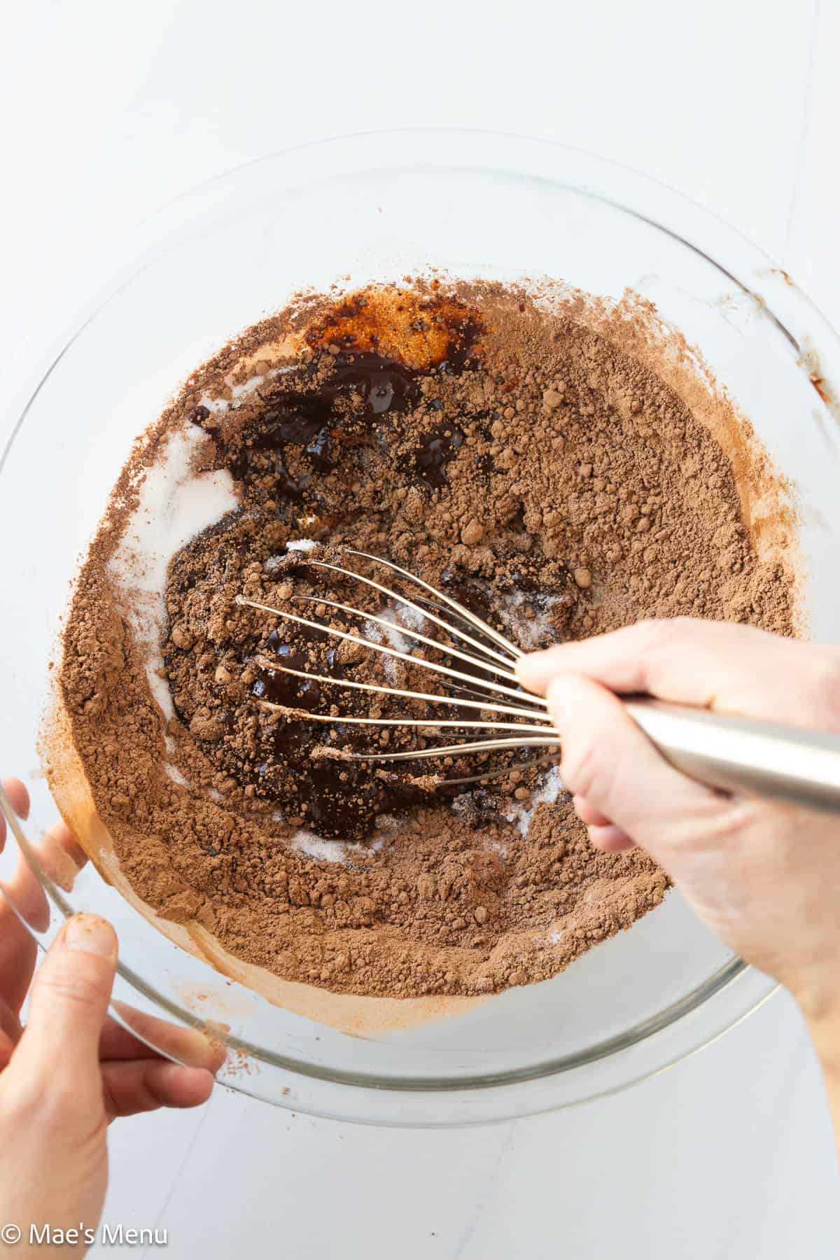 Whisking the sugar and cocoa powder into the melted chocolate mixture.