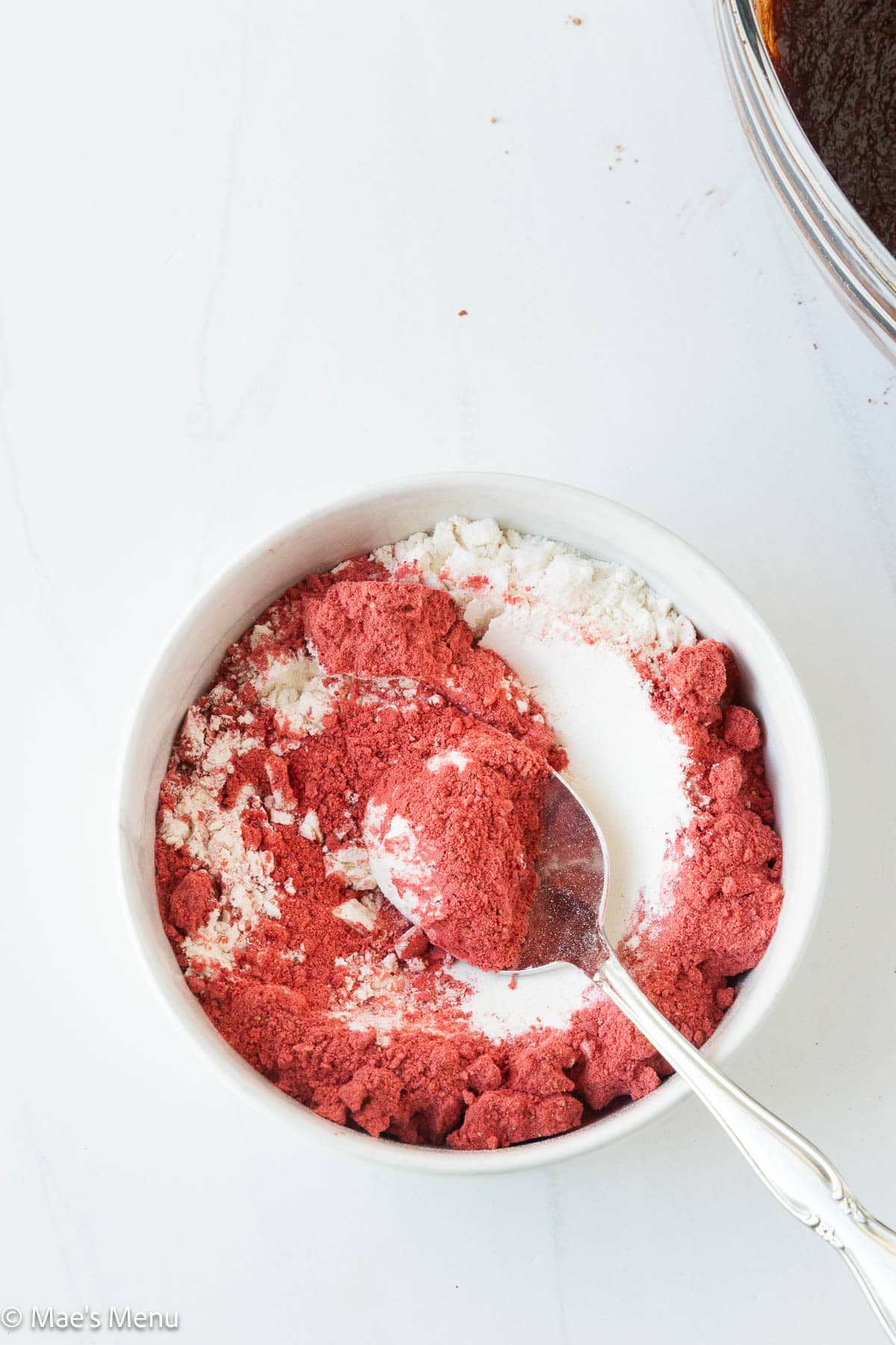 Mixing the strawberry powder into the flour and salt mixture.