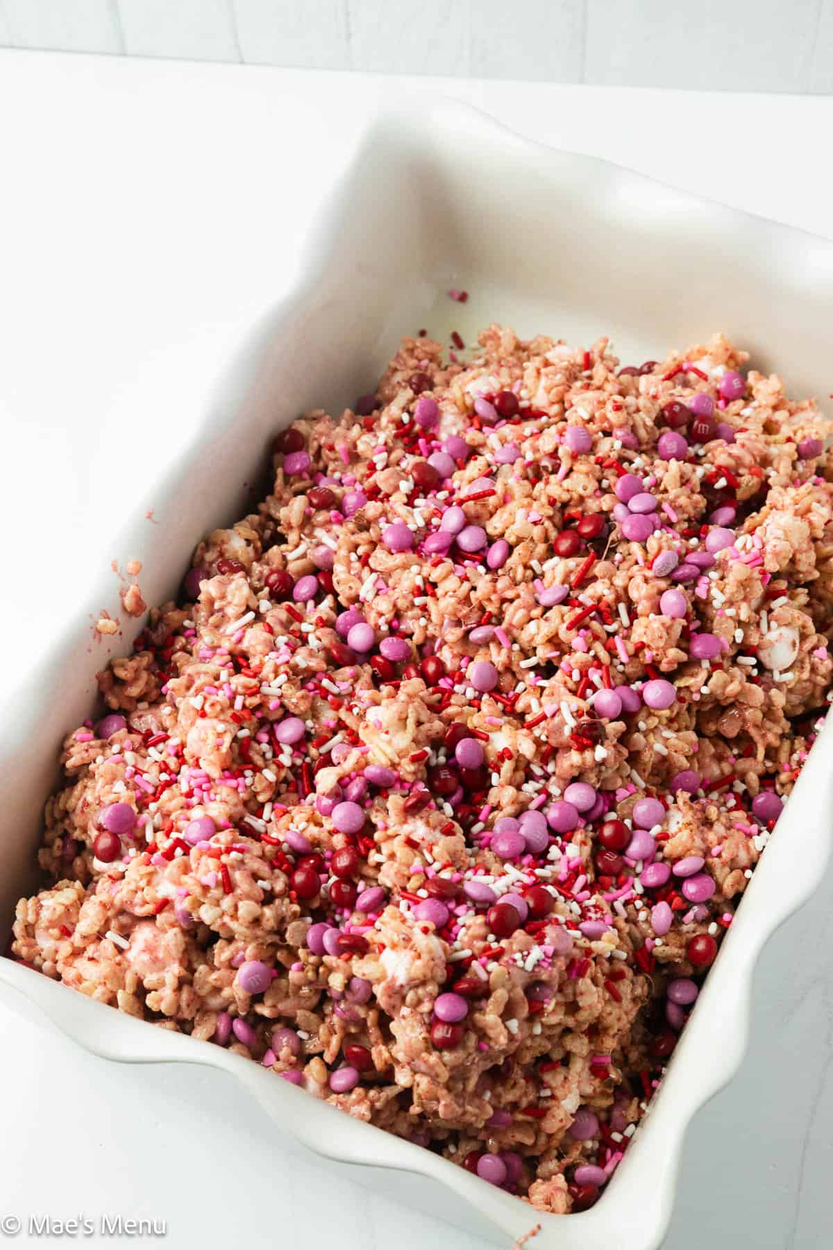 The rice krispies topped with M&Ms and sprinkles before pressing down.