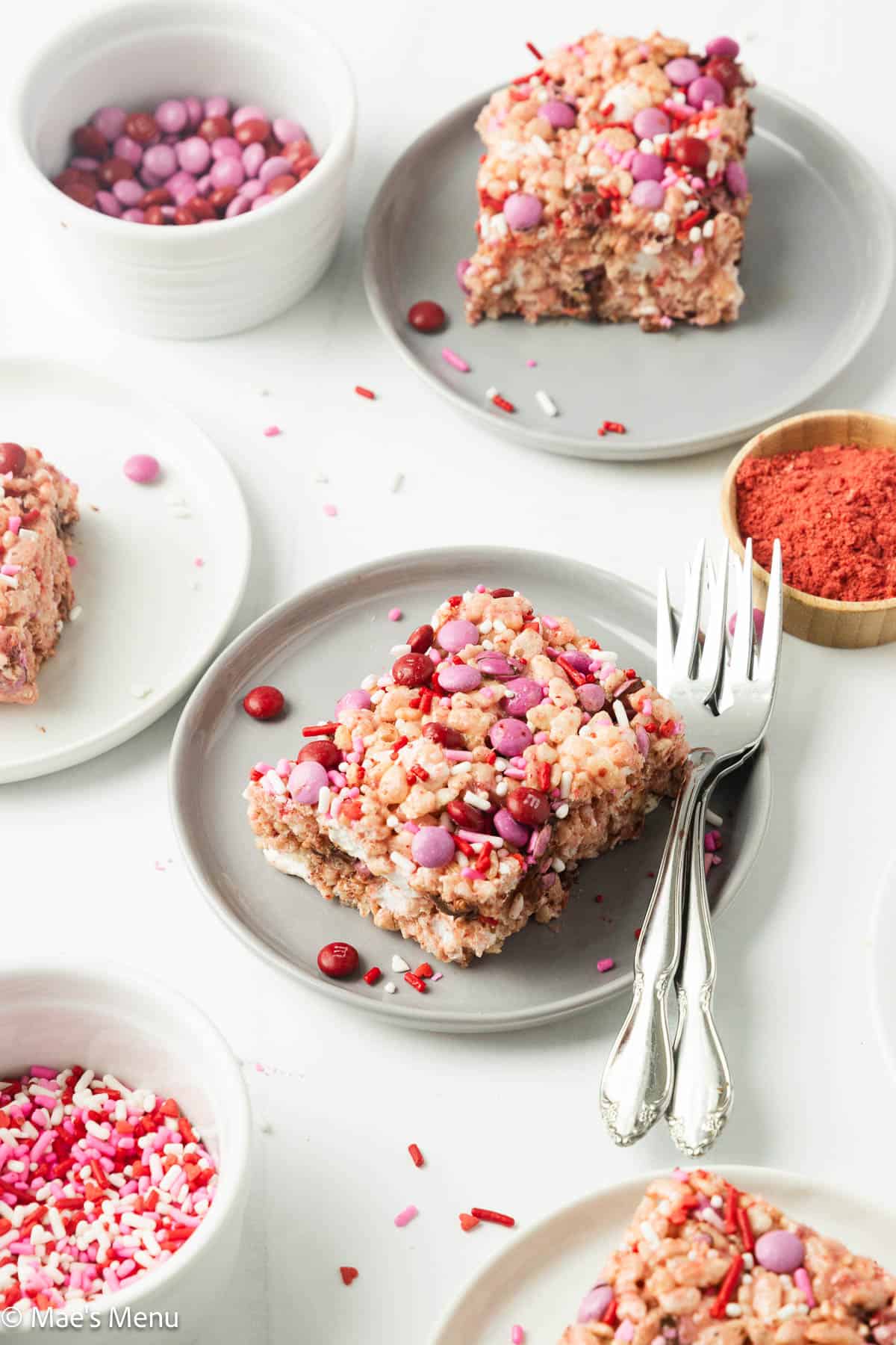 An angled shot of small plates of strawberry rice krispie treats on the counter. 
