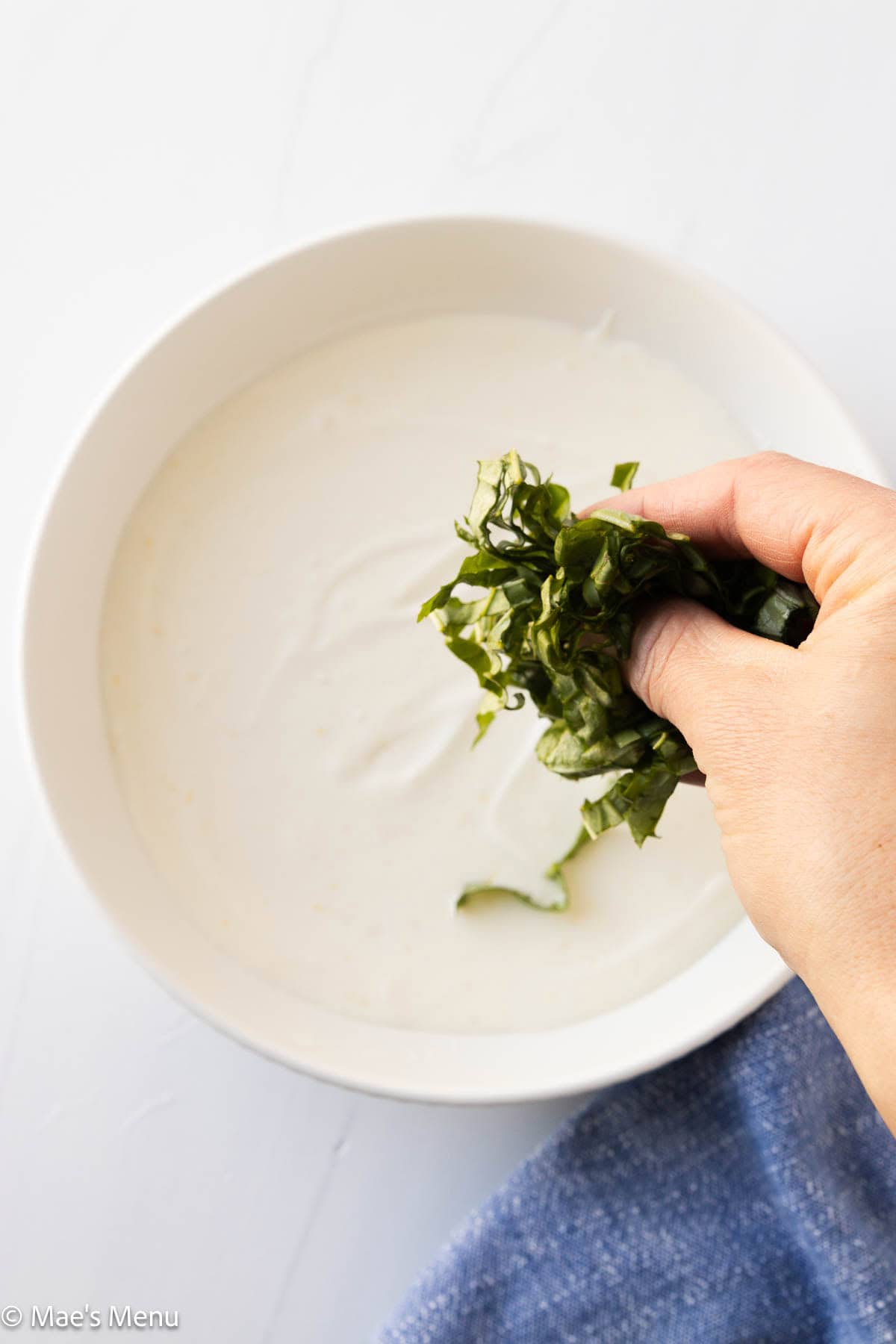 Topping the cottage cheese dip with the fresh sliced basil.