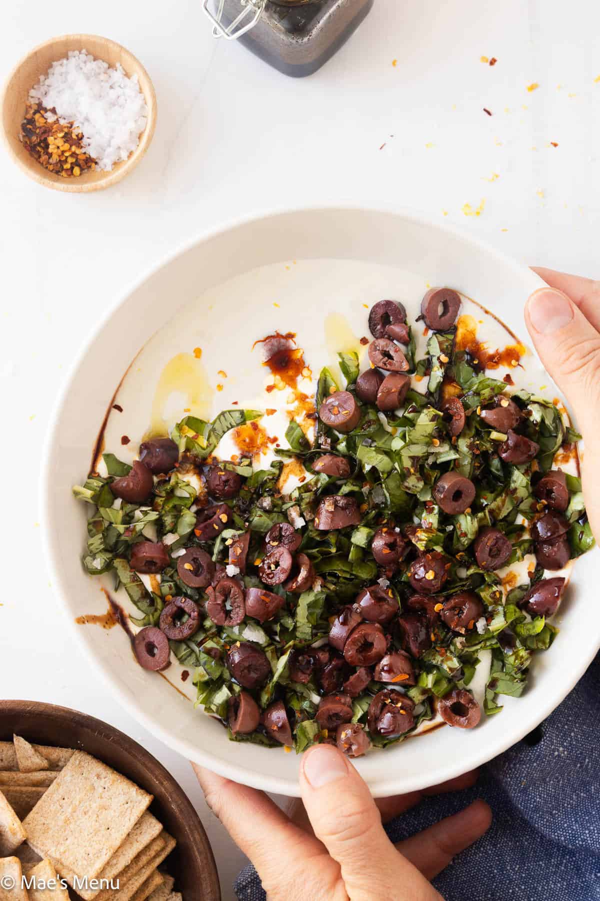 Two hands serving a bowl of whipped cottage cheese dip.