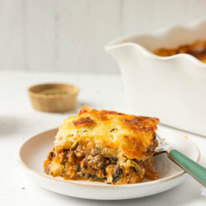 A side shot of a slice of zucchini lasagna on a plate.