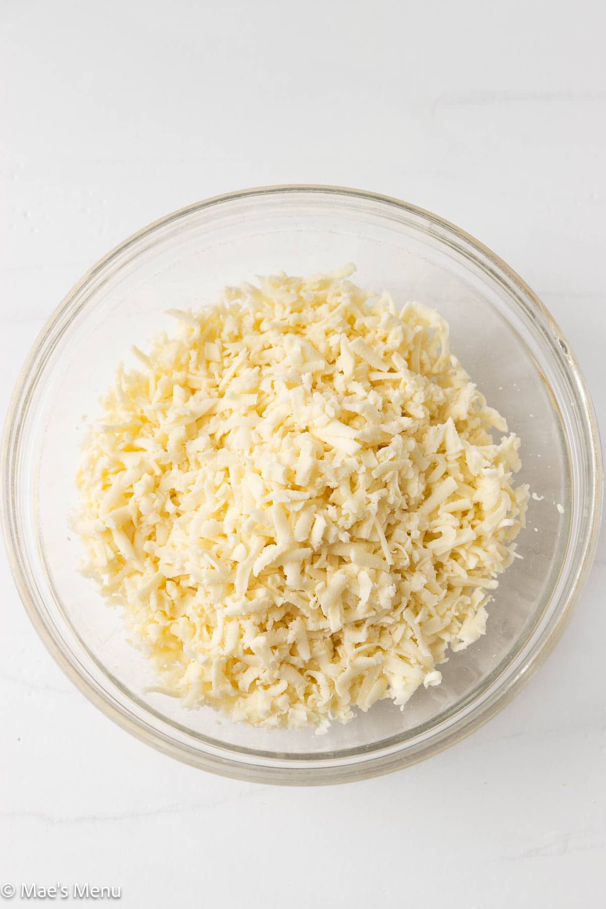 An overhead shot of a bowl of shredded mozzarella.