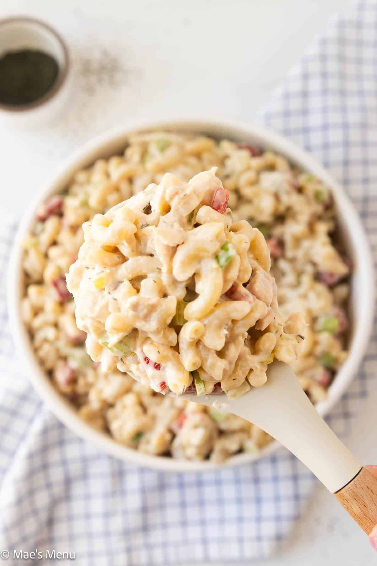 An overhead shot of a scoop of tuna pasta salad over the serving bowl.