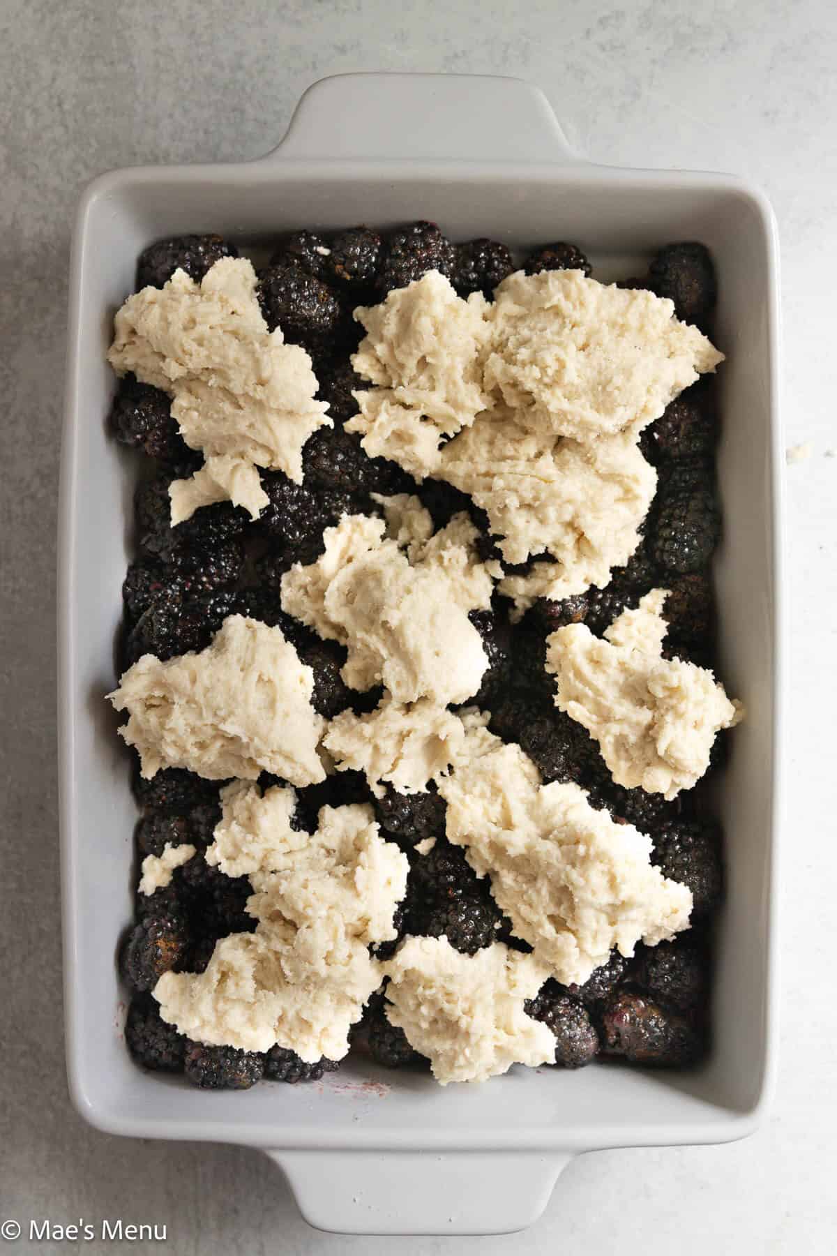 An overhead shot of a pan of blackberry cobbler before baking.