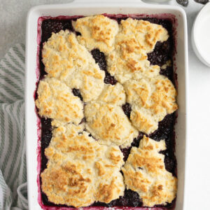 An overhead shot of a pan of fresh-baked blackberry cobbler on the counter.