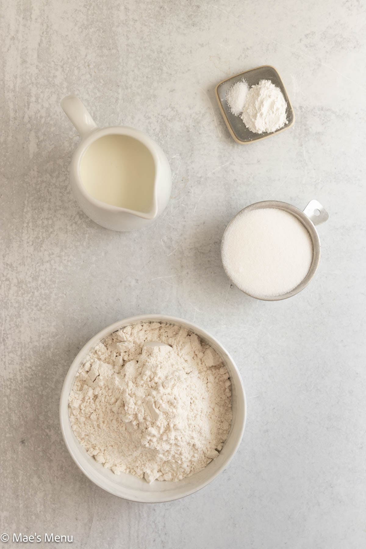 Flour, buttermilk, sugar, and baking powder on the counter.